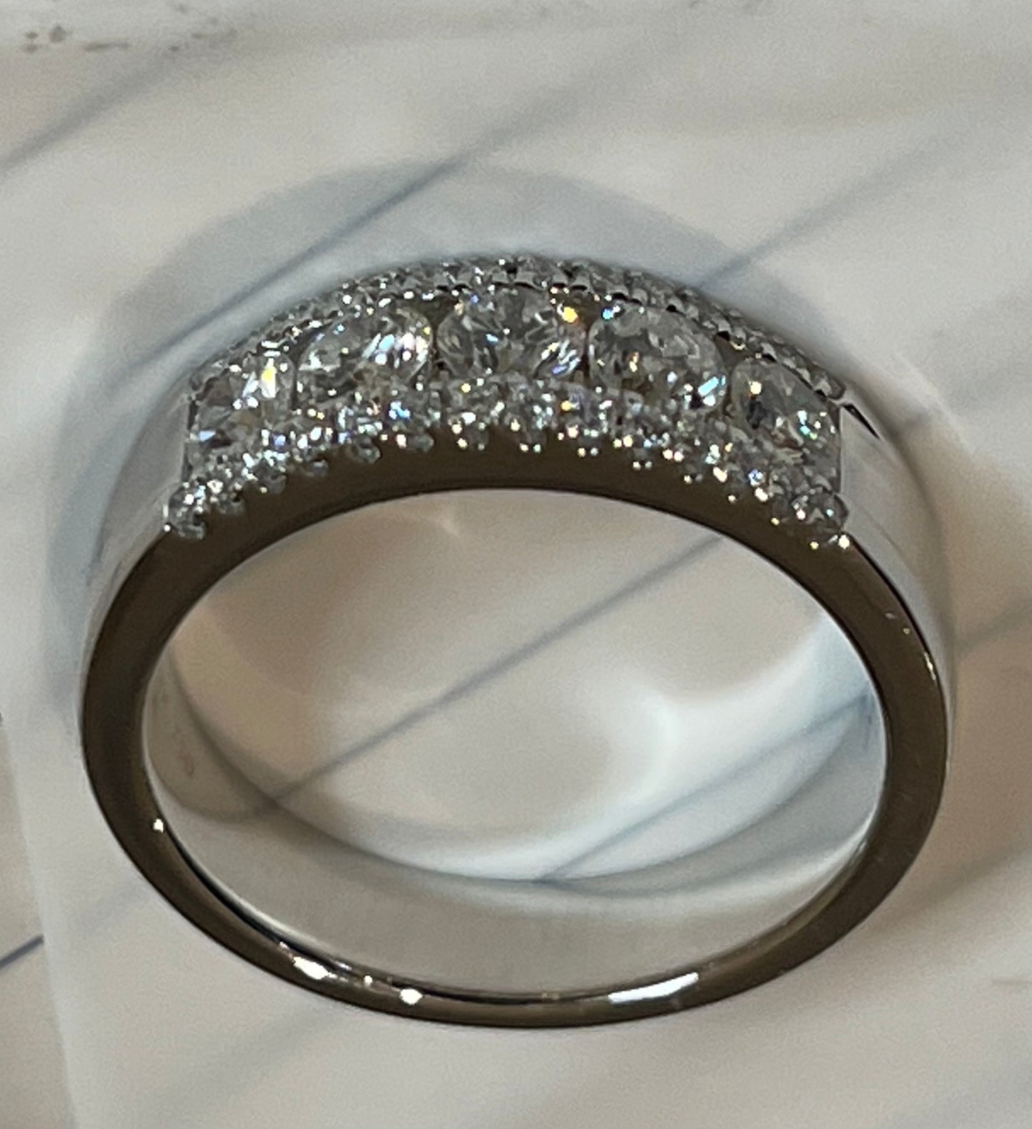 This beautifully designed band features three rows of sparkling diamonds set in 18kw gold.