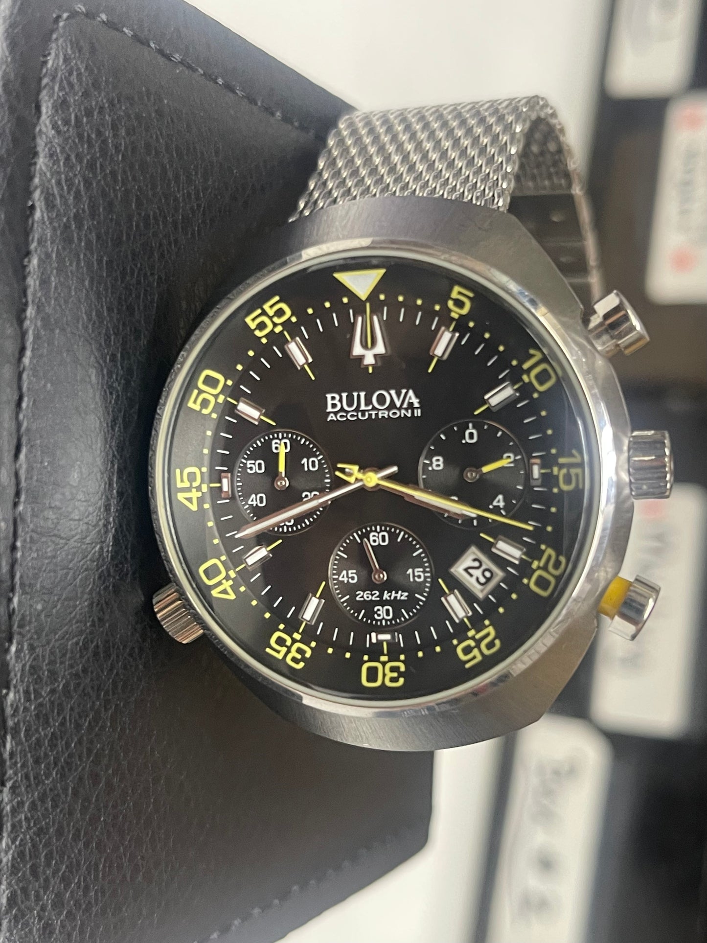 This is a Bulova Accutron II Lobster Chronograph watch with a black dial and a stainless steel mesh bracelet